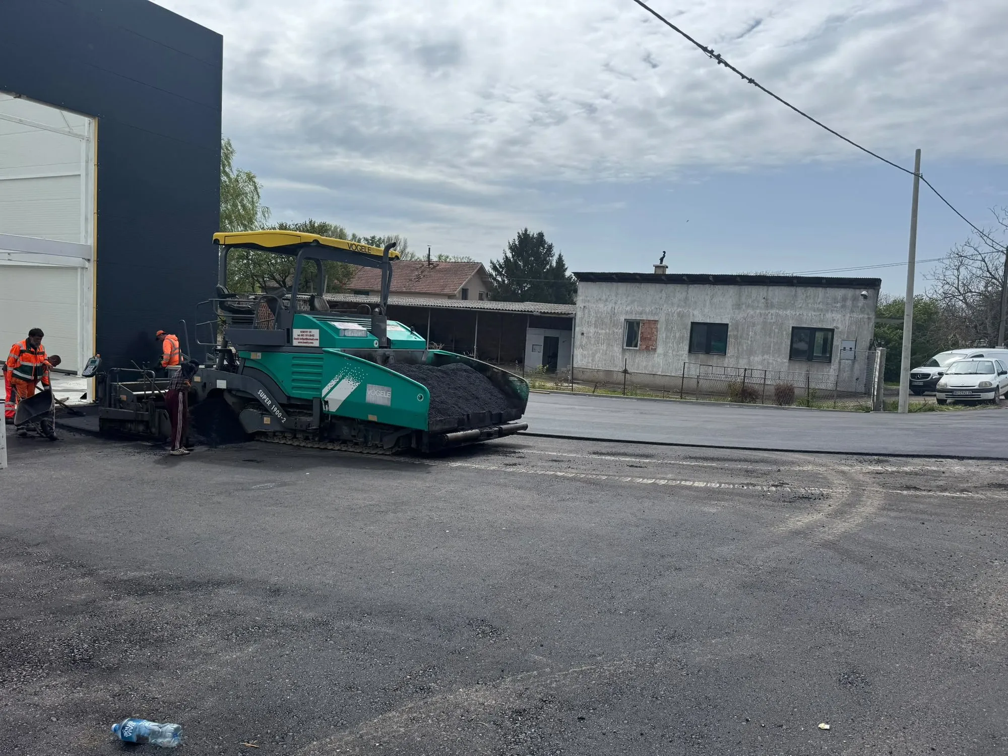 Finišer ugrađuje asfalt na parkingu poslovnog objekta