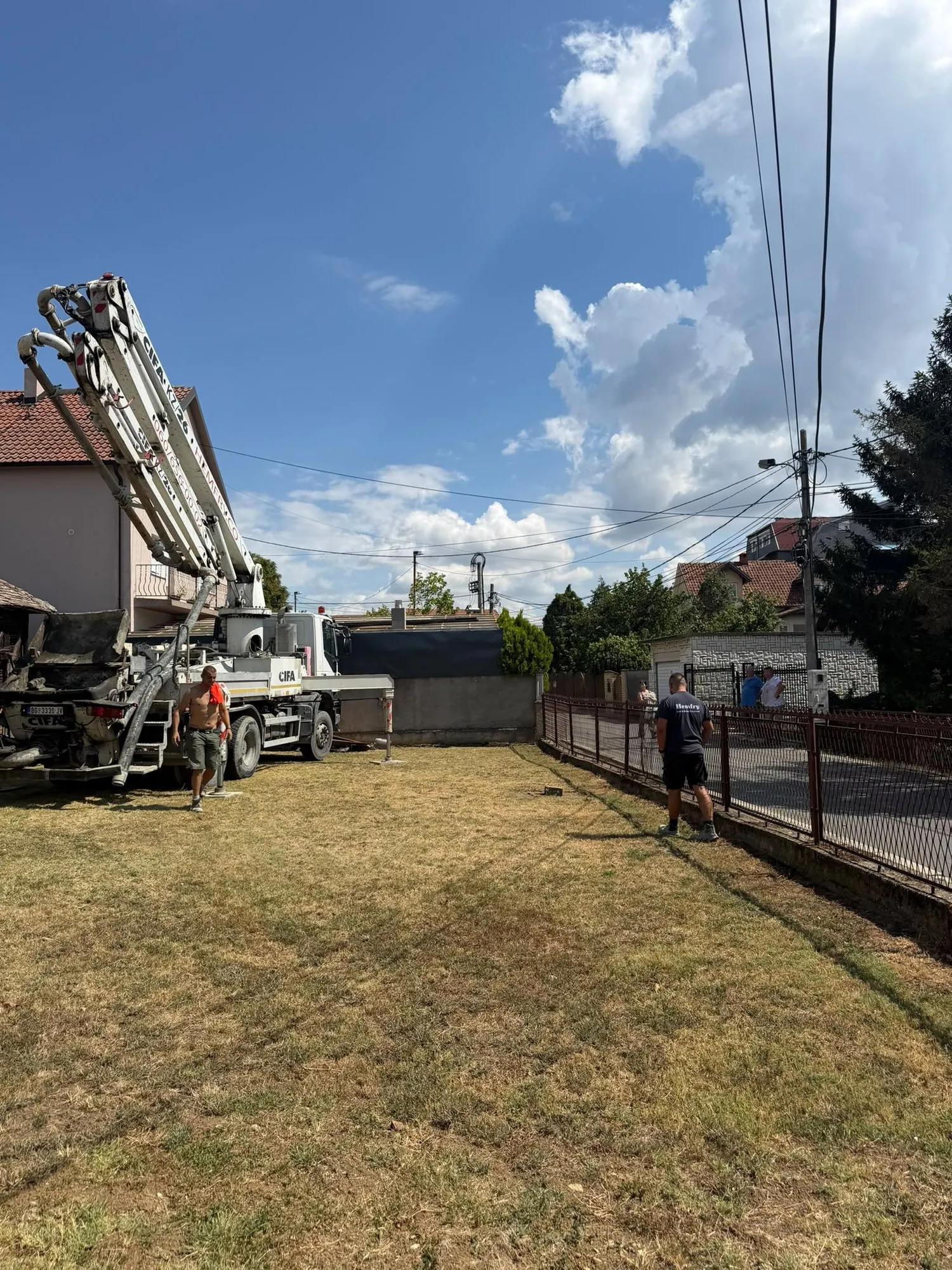 Pumpa za beton sa krakom preko ograde u dvorište porodične kuće