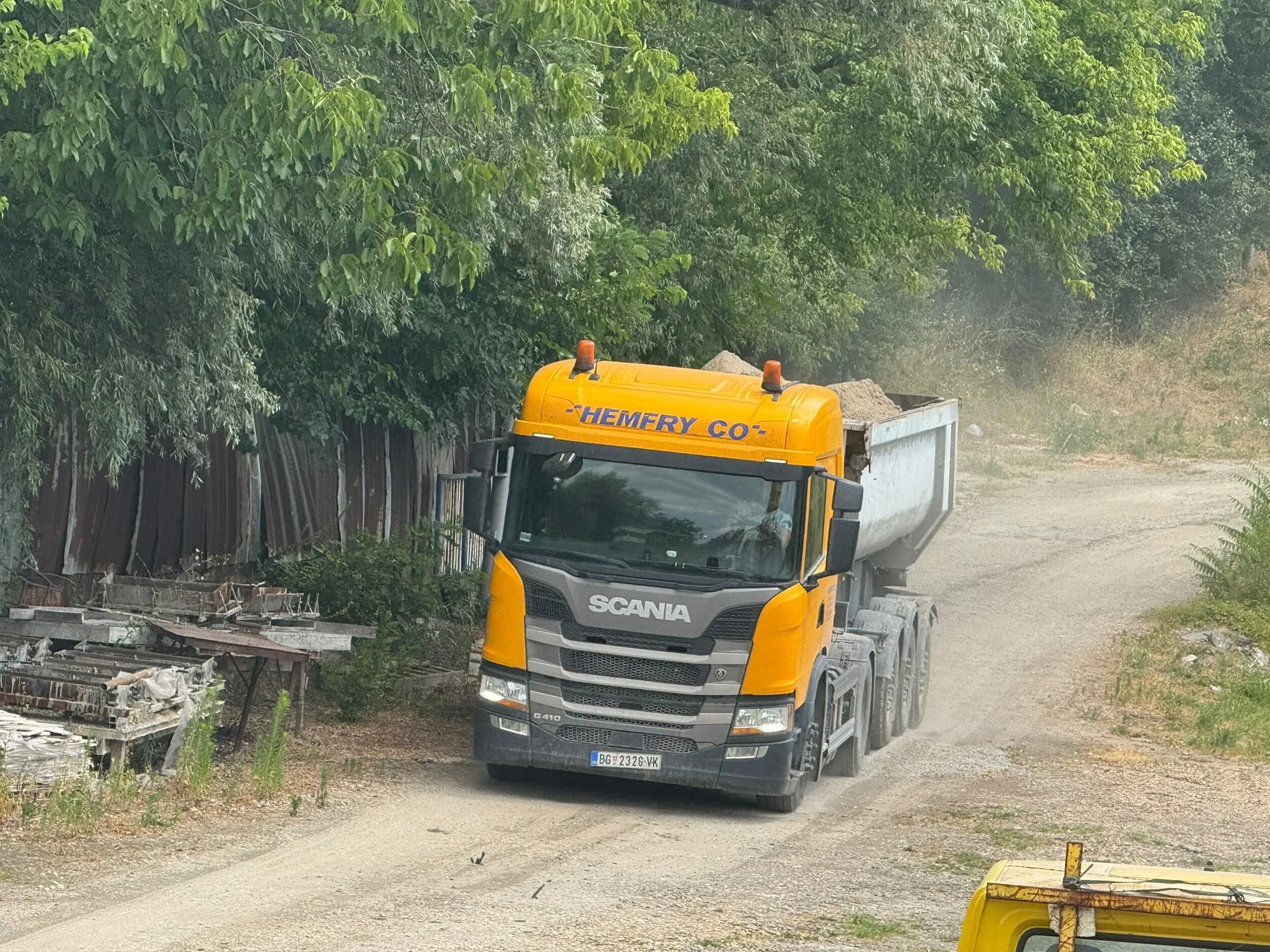 Žuti Scania kiper Hemfry Co na makadamskom putu