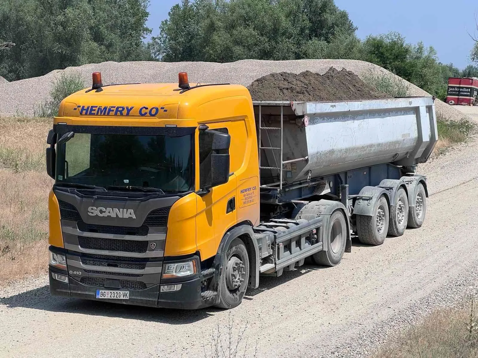 Žuti Scania kiper Hemfry Co utovaren rasutim materijalom