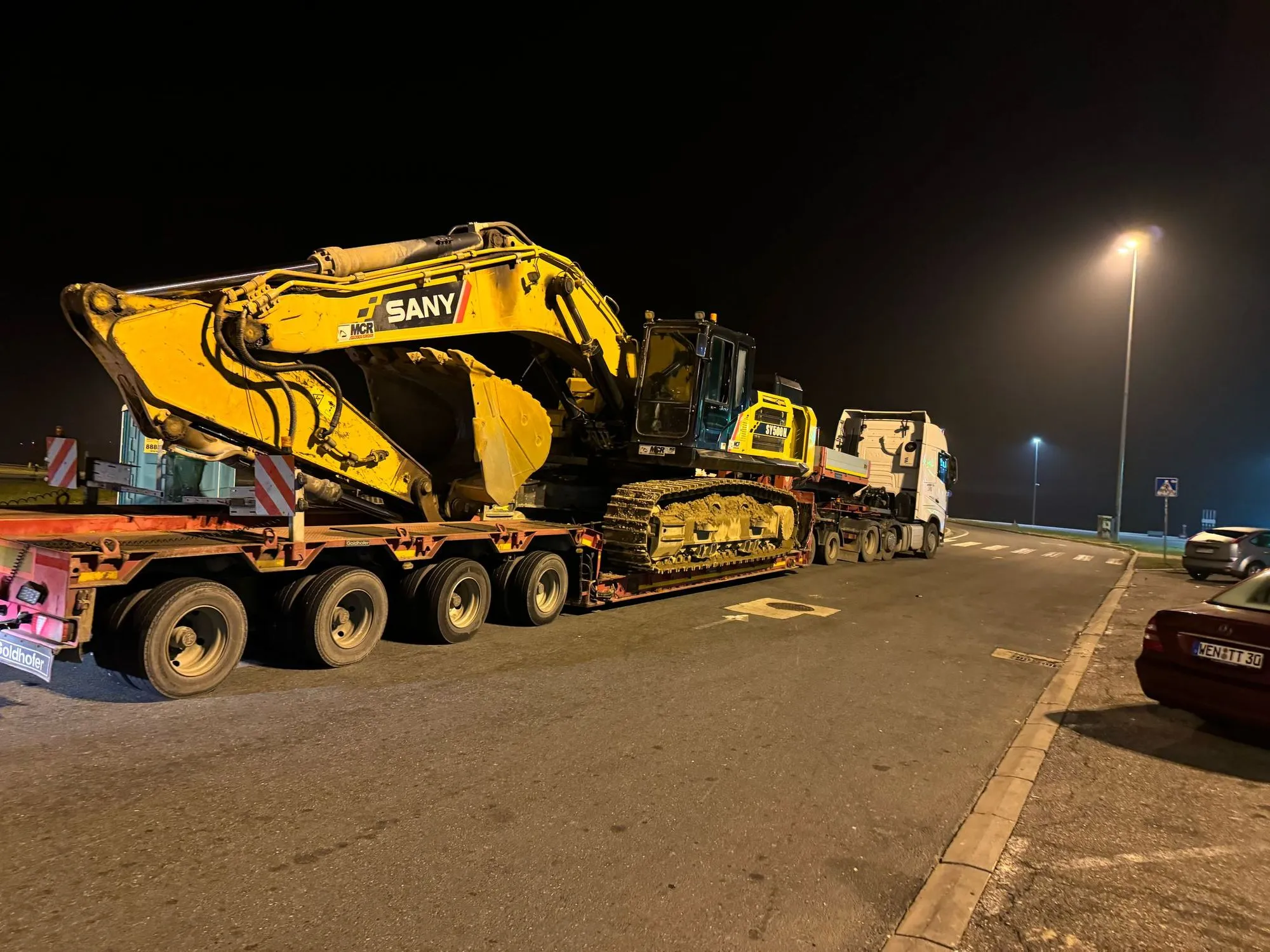 Bager SANY SY500H na niskonosećoj prikolici tokom noćnog transporta
