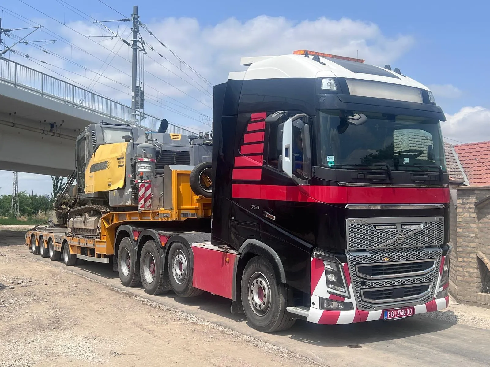 Tegljač Volvo FH16 sa bagerom na niskonosećoj prikolici